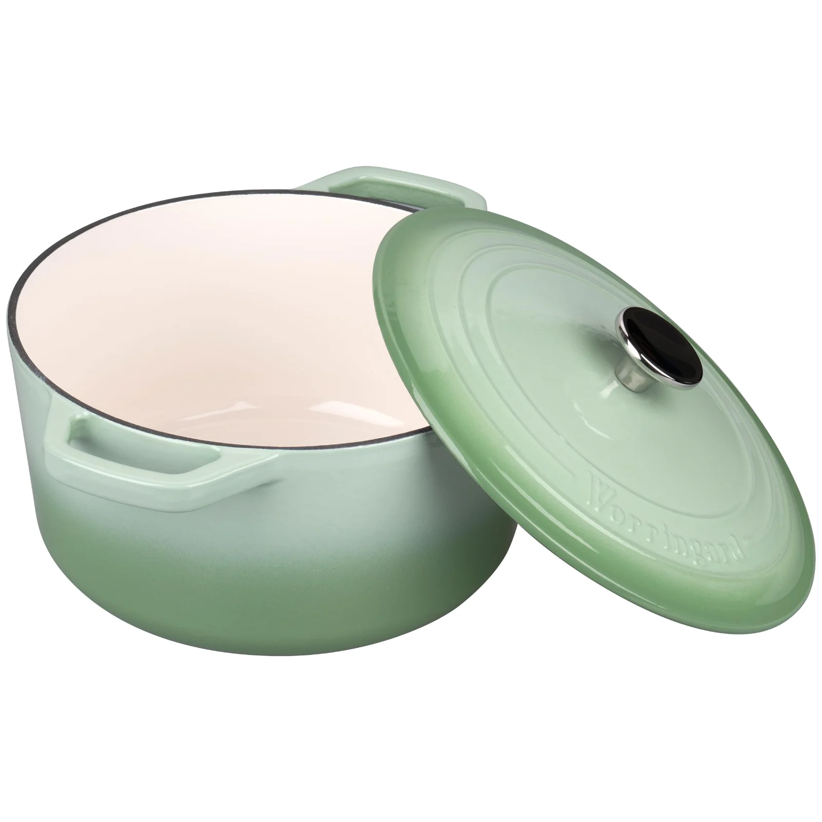 The cream enamel interior of a sage green VORRINGARD Dutch oven with the lid tilted off